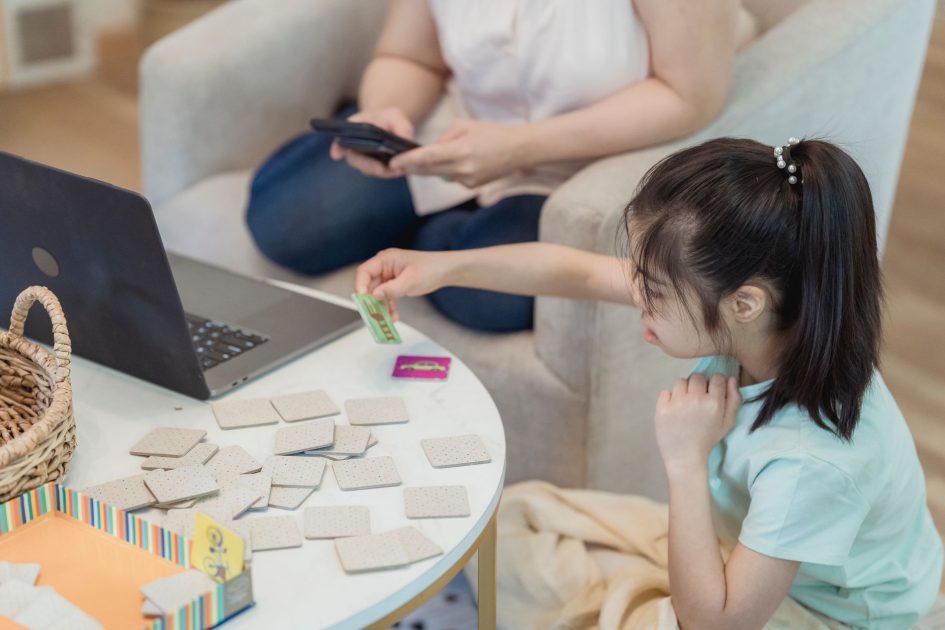 Uji Ketelitianmu: Temukan Kata Tersembunyi & Jaga Kesehatan 2025 1 Asian girl focused on memory game at home with cards, enhancing cognitive skills.