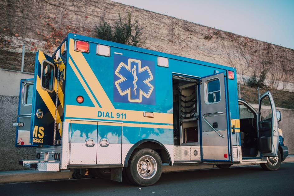 30 Tahun Membeku Everest Jenazah: Kisah Tragis & Pelajaran Kesehatan 1 Blue ambulance parked on roadside with open doors, emergency medical service vehicle.