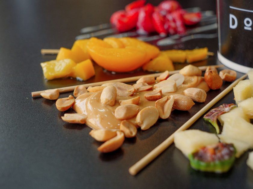 HiFruit Baru: 7 Cara Menikmati Sensasi Buah Segar & Sehat 1 Close-up of assorted fruits, nuts, and peanut butter on skewers, showcasing a vibrant, healthy snack.