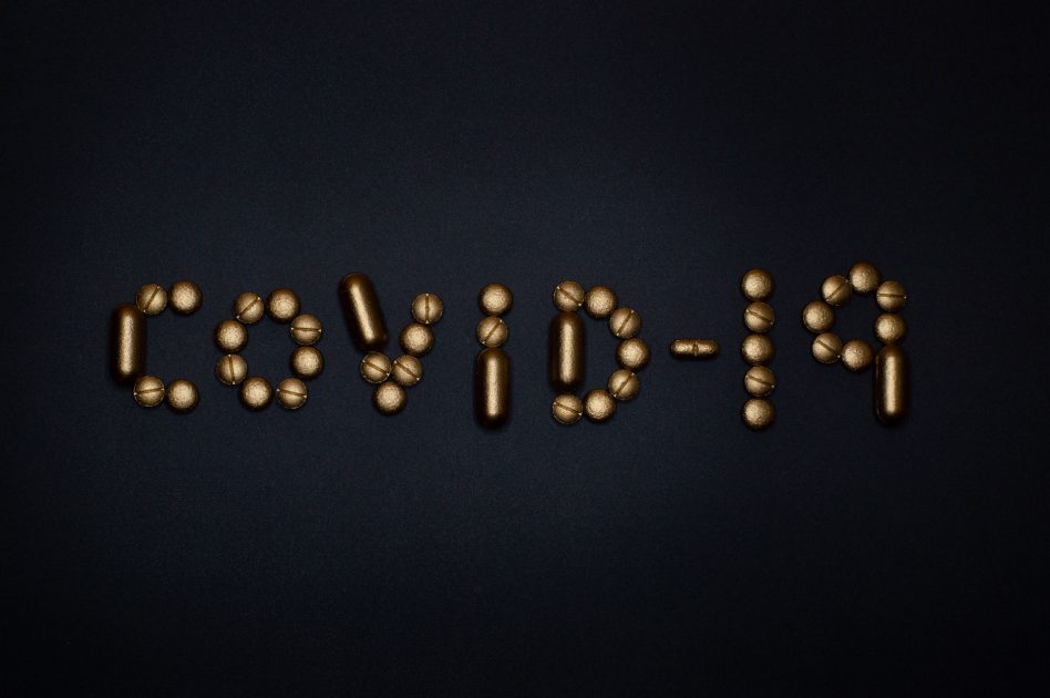 Infografis Varian Baru COVID-19: Panduan Lengkap 2024 1 Artistic representation of COVID-19 using golden pills on a black background, symbolizing healthcare and treatments.