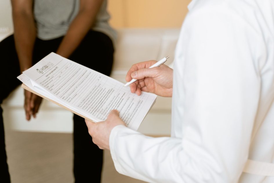 Kenapa Inspirasi Sering Muncul BAB? 7 Penyebab & Solusi 1 Healthcare professional reviews medical form during patient consultation in a clinic setting.