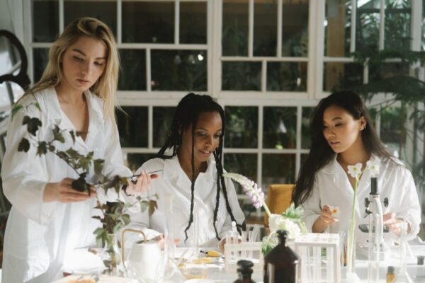 Three women scientists examining plants in a laboratory setting.