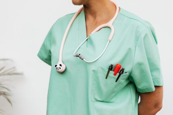 Close-up of a doctor in scrubs with a panda themed stethoscope and pocket pens.