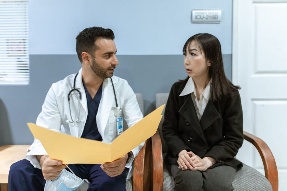 Healthcare professional consults patient in clinical setting. Medical discussion and diagnosis.