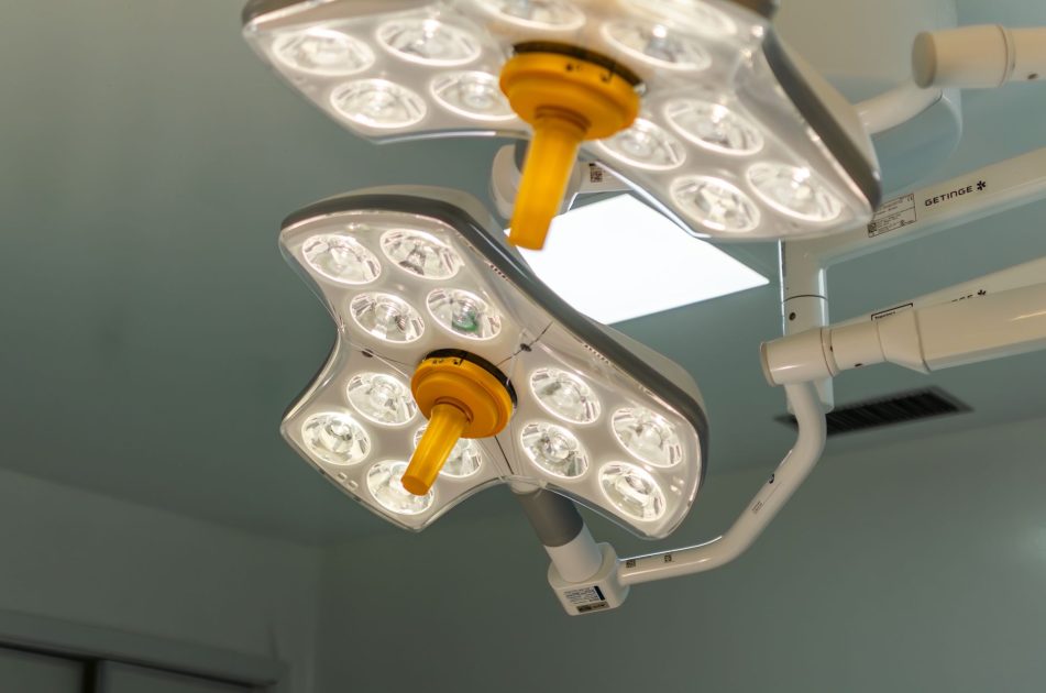 Pengadaan Puluhan Alkes RSUD NTB: 7 Strategi Efisien Rp21 Miliar 1 Bright LED surgical lights in a hospital operating room, emphasizing technology and healthcare.
