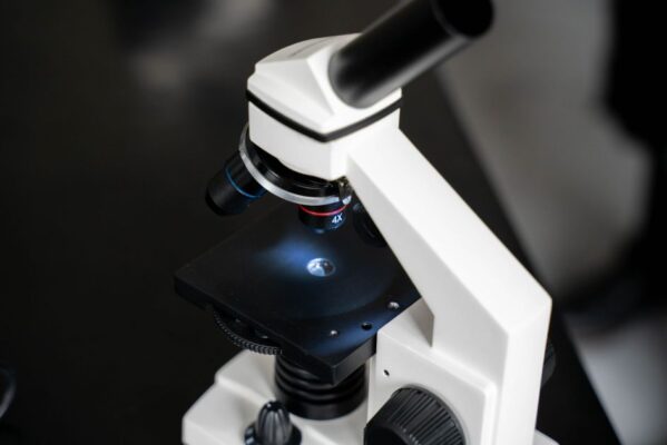 Close-up view of a laboratory microscope with selective focus, ideal for scientific use.