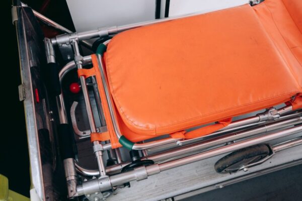 Close-up view of an orange stretcher inside an ambulance, emphasizing medical equipment.