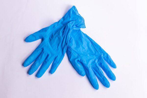 A pair of disposable blue latex gloves on a clean, white surface representing hygiene and safety.