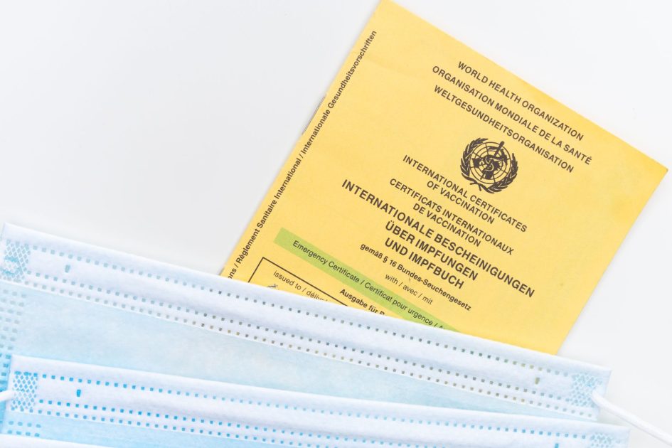 7 Langkah Sertifikasi Alat Lab ke KEMENKES: Syarat, Biaya & Timeline 1 An international vaccination certificate with face masks on a white surface symbolizing health safety.