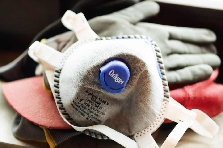 Close-up of a protective mask and work gloves on a building site.