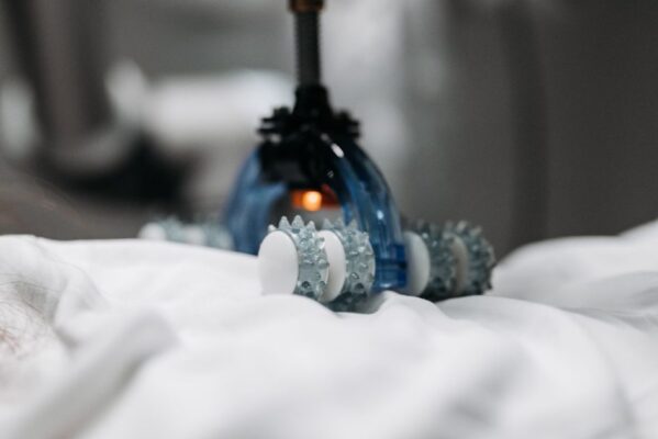 High-tech massage gadget resting on white fabric, showcasing innovation in relaxation technology.