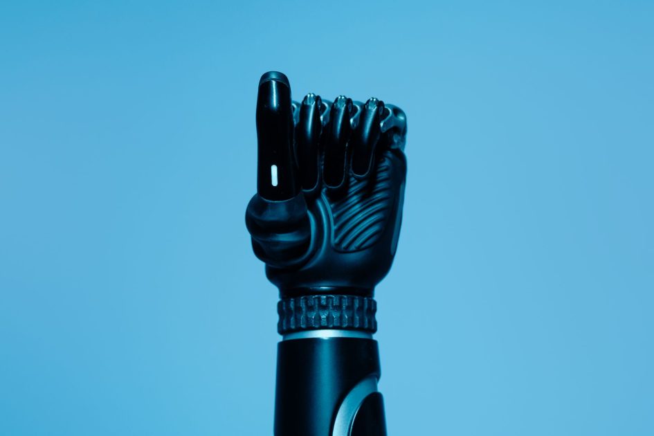 Alat Bantu Menjadi Rekan Kerja: 7 Cara AI Transformasi Layanan Kesehatan 2025 1 Close-up of a prosthetic arm in a vibrant blue setting, showcasing advanced technology.