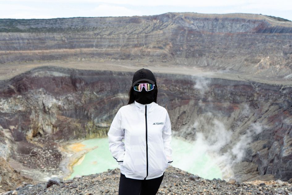 Anak Krakatau Erupsi: 9 Cara Lindungi Diri dari Abu Vulkanik 1 Person in protective gear standing near a steaming volcanic crater during daylight.