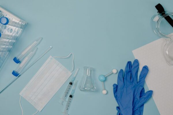 An overhead shot showcasing various laboratory protective gear and equipment on a blue background.