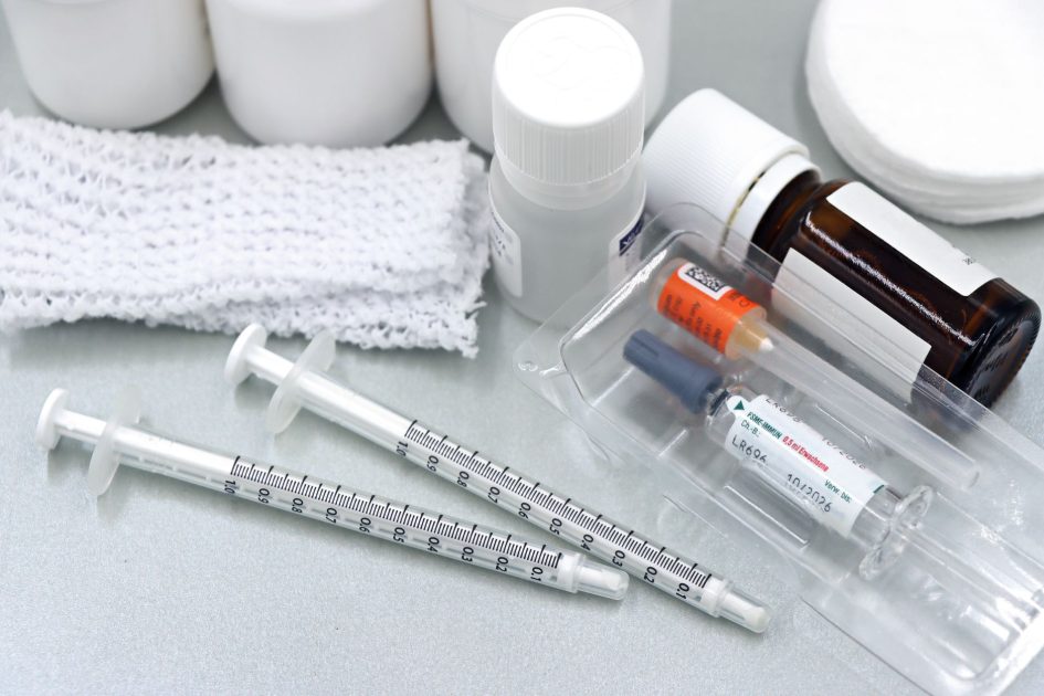 Cegah Demam Tifoid Bio Farma: 7 Panduan Lengkap Vaksinasi 1 Flat lay of medical tools and vaccines, including syringes and bottles, on a white surface.