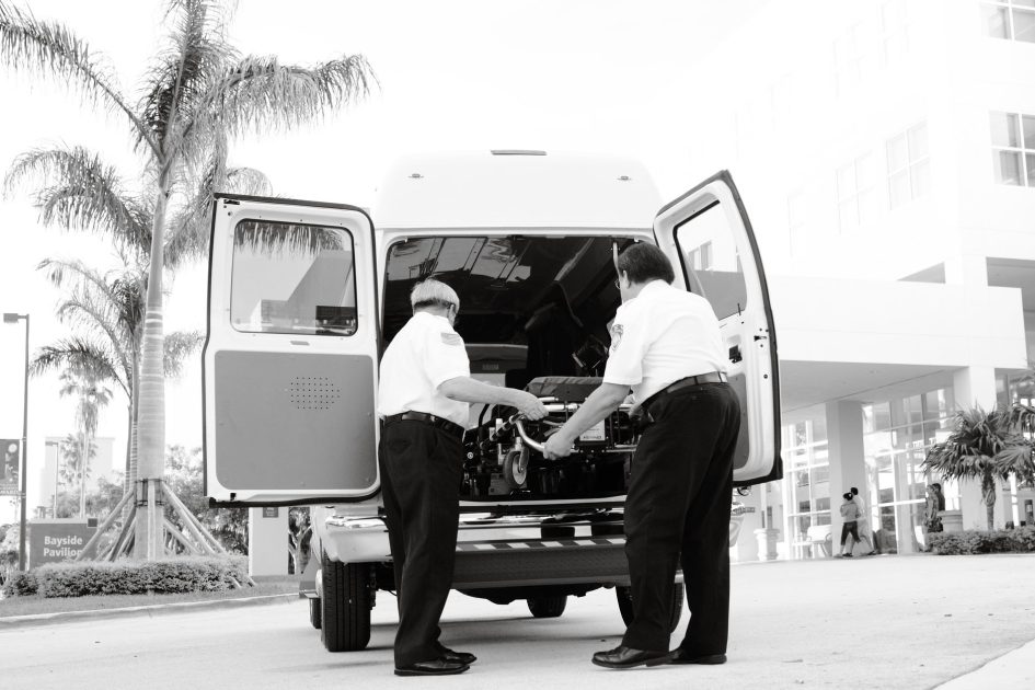 Curi Alat Medis RSUD Pandan: 9 Strategi Keamanan Penting 1 Black and white photo of emergency responders loading equipment into an ambulance outside a medical building.