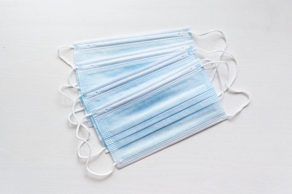 Influenza A Picu Pneumonia: 7 Gejala Wajib Diwaspadai 1 A stack of blue surgical face masks neatly arranged on a white background.