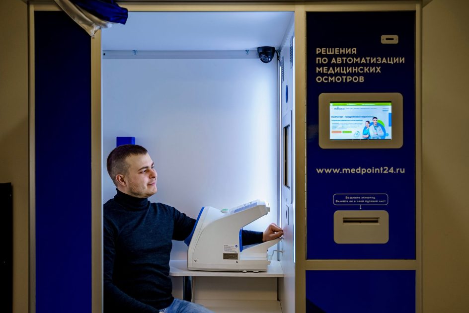 Mbappe Gagal Penalti: 7 Efek Tekanan pada Otak & Performa 2025 1 Caucasian man smiling while using automated healthcare booth for blood pressure and health checks.