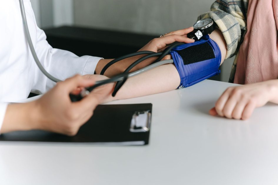 Menjaga Kebugaran Pengunjung Ikuti Layanan: 7 Panduan Lengkap 2025 1 A healthcare worker uses a sphygmomanometer to check a patient's blood pressure in a medical office.