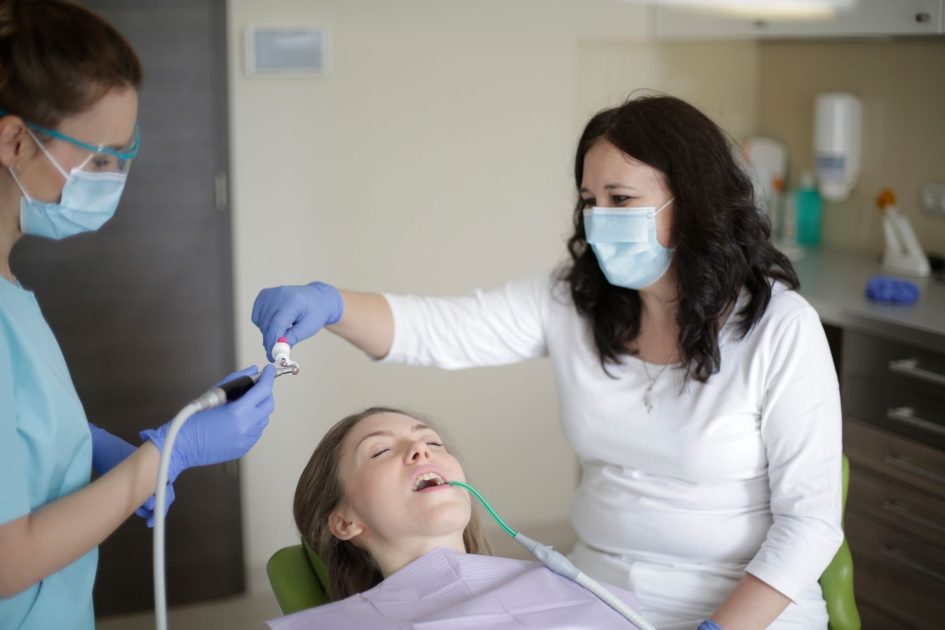 Menjajal Sendiri Produk Tambal Gigi: 7 Risiko & Cara Aman 1 Middle aged female lying in dental chair with tube suction in mouth while getting professional treatment to fill cavity in tooth in dental clinic