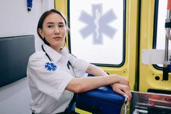 Asian woman paramedic inside an ambulance ready for emergency response.