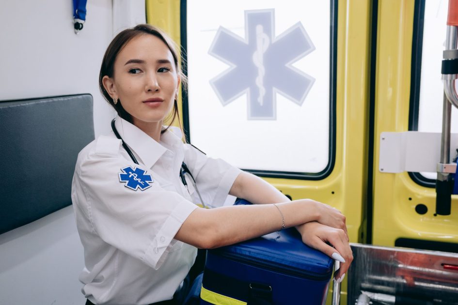 Asian woman paramedic inside an ambulance ready for emergency response.