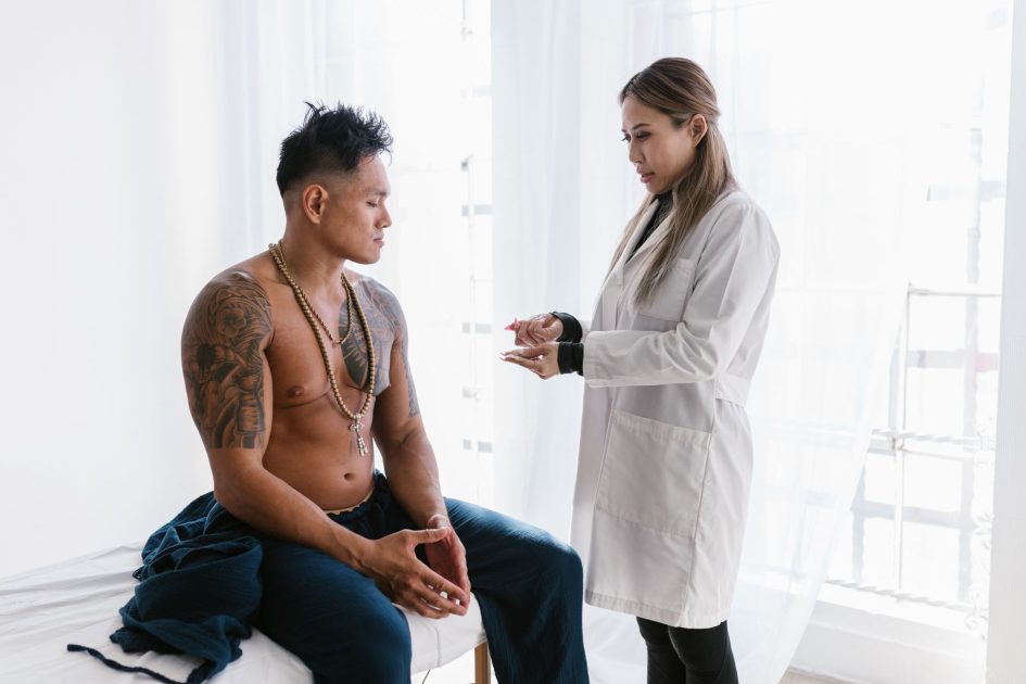 Menyoal Vasektomi KB Pria Dijalani: Panduan Lengkap 2024 1 A doctor consults with a shirtless man in a clinical setting. Healthcare interaction.