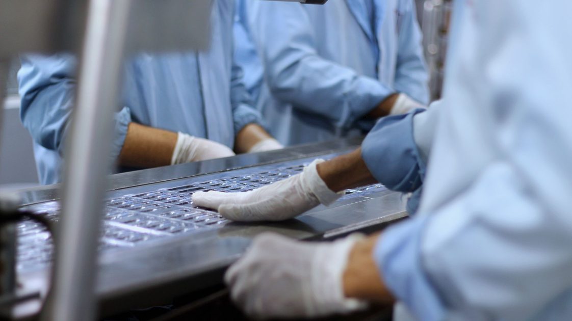 Microfluidics Farmasi: 7 Aplikasi & Teknologi Miniaturisasi Lengkap 1 Workers in a pharmaceutical facility packaging tablets in Islamabad.