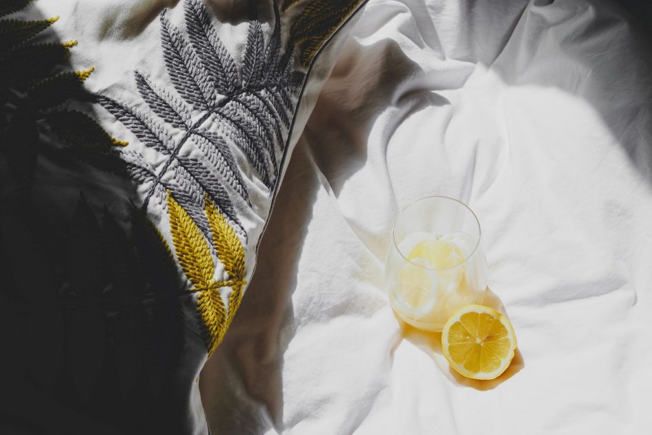Minum Air Lemon Pagi Hari: 7 Fakta Ilmiah yang Perlu Anda Tahu 1 Bright morning scene with lemon water on embroidered bedding in Paris, capturing fresh and calm vibes.