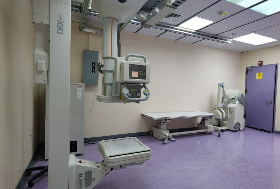 Pemprov NTB ITDC Urunan Bayar: 7 Strategi Alkes Terpadu 2024 1 Interior view of a well-equipped hospital X-ray room with medical imaging devices.