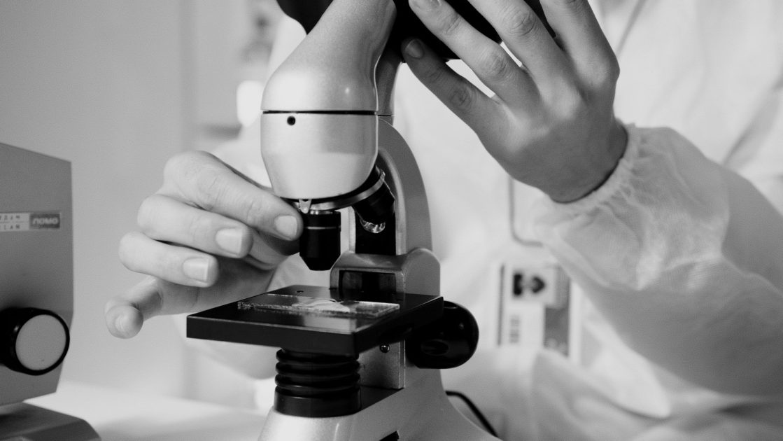 Maintenance Schedule Alat Lab Farmasi: Panduan Lengkap 1 A scientist in a lab coat using a microscope for research in a laboratory setting.