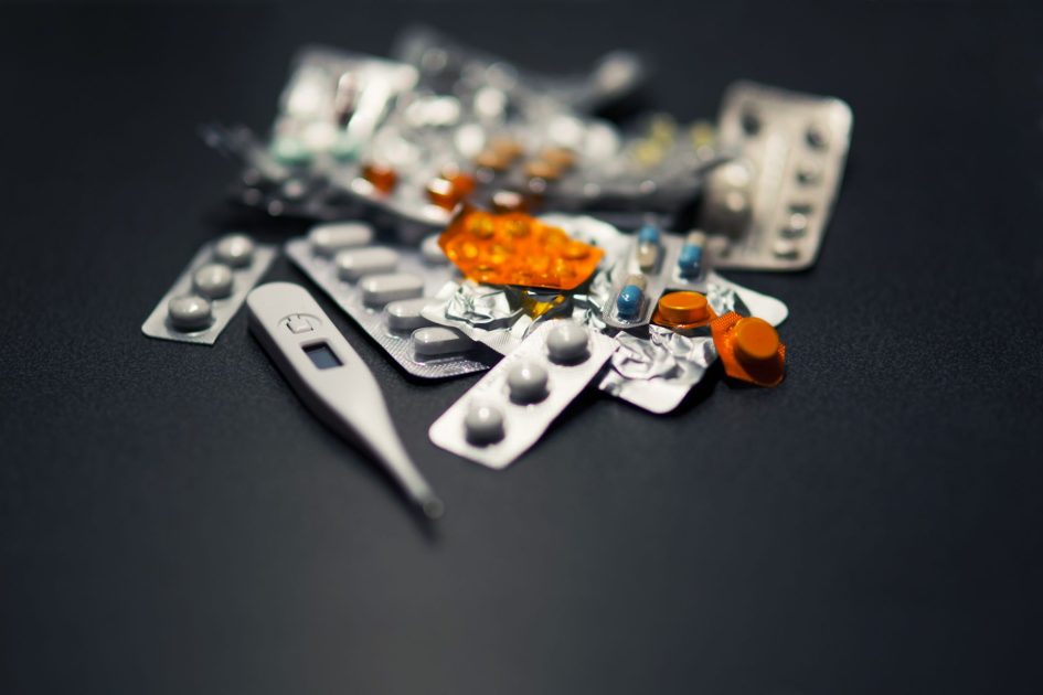 Ramai Kasus Keracunan MBG: Mungkinkah Jadi KLB? 7 Langkah Proteksi 1 Close-up of various pills and a digital thermometer against a dark background.
