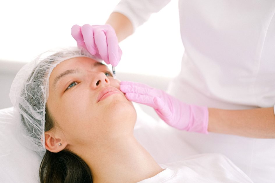 Skin Booster Kulit Mayat Ala Korea: 7 Perbedaan dengan Hyaluronic Acid 1 Woman receives cosmetic injection in clinical setting, enhancing beauty using modern techniques.