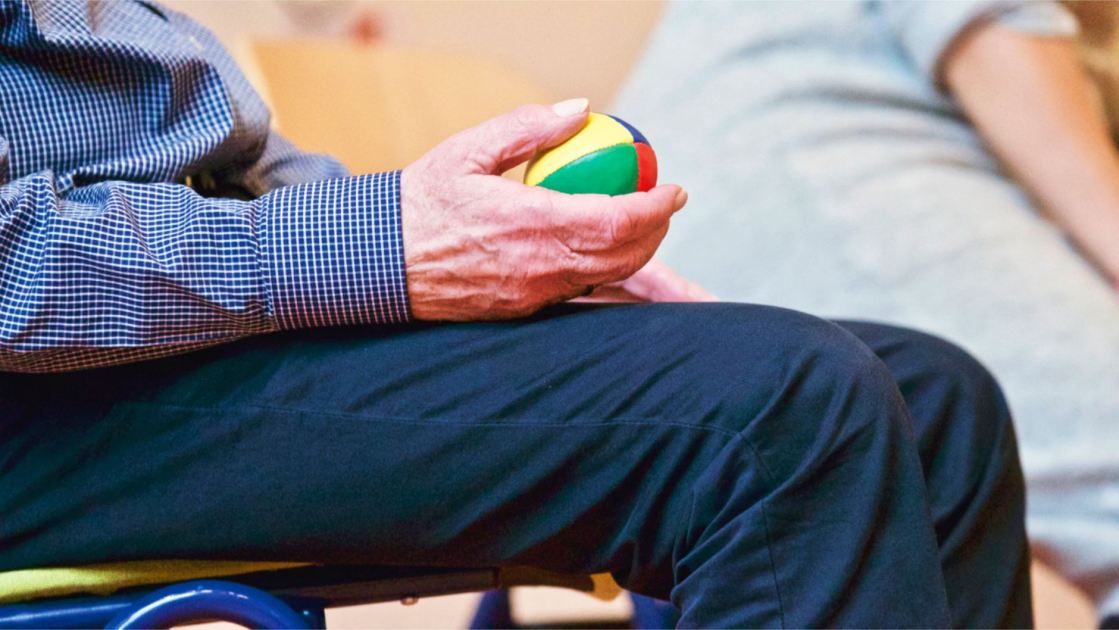 Tak Heran Como Punya Banyak Fans Lansia: 7 Panduan Kesehatan Optimal 1 Elderly man holding a colorful therapy ball indoors, promoting relaxation and health.