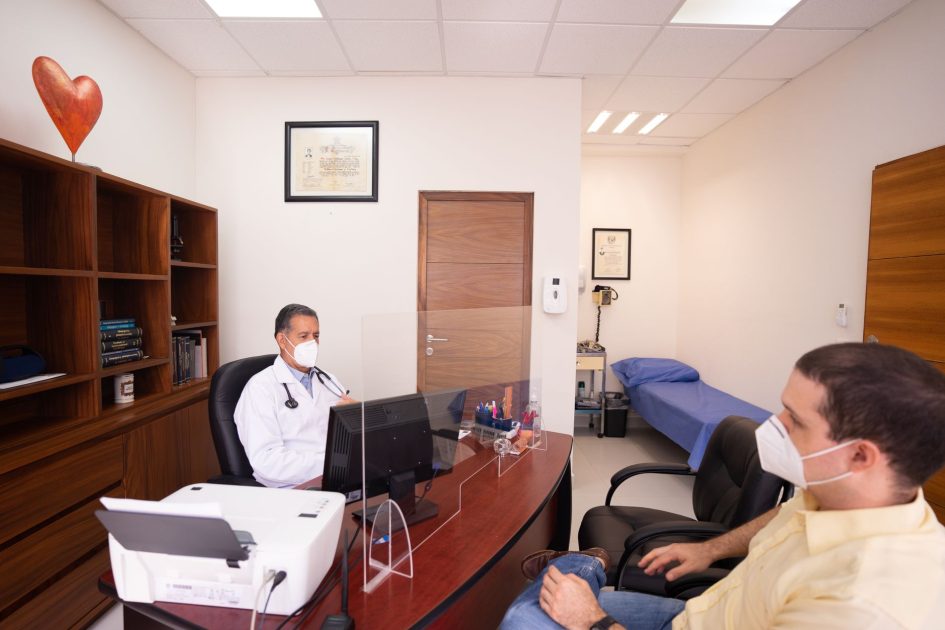 Doctor and patient with masks in medical clinic, emphasizing healthcare safety.