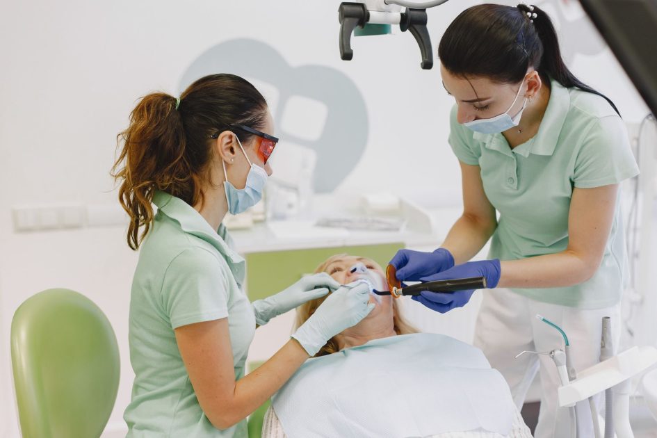 Fluoridasi Gigi Klinik Perlu atau Tidak? 7 Panduan Lengkap 2025 1 Dentists performing a dental procedure on a patient in a contemporary clinic.