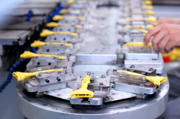 Close-up of a factory production line with yellow components being assembled.