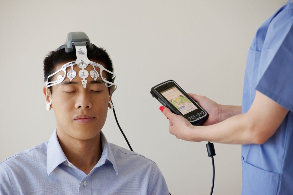 Infografis 5 Sikap Jadi Tanda Kecerdasan: Panduan Lengkap 1 Healthcare professional conducting an EEG examination using a Brainscope device on a male patient.