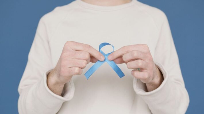 A person holding a blue awareness ribbon symbolizing support for various causes.