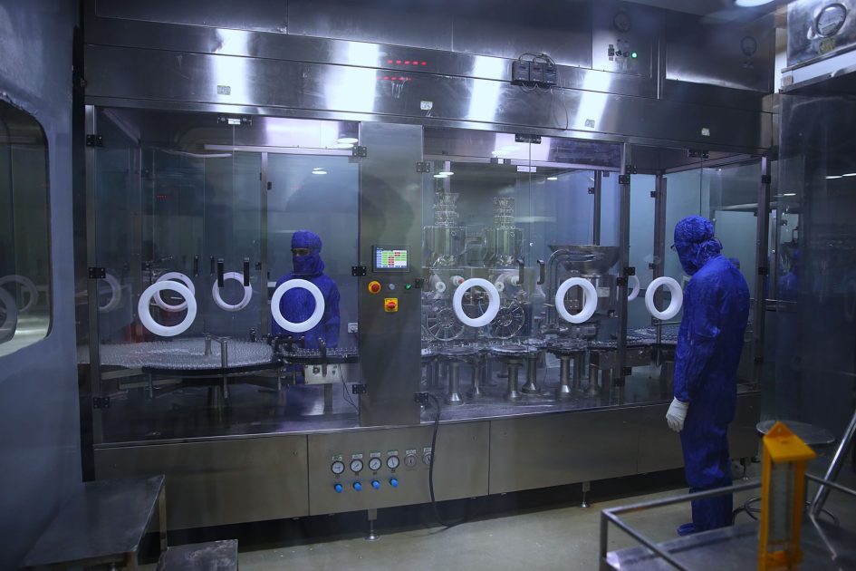 Manfaatkan AI Urus Izin Edar: Panduan Cepat 2025 1 Workers in protective gear inside a sterile pharmaceutical manufacturing plant in Rawalpindi, Pakistan.