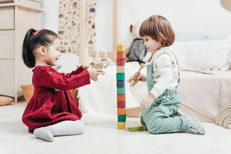 Morinaga Door of Future Ajak: 7 Panduan Mengenali Potensi Anak 1 Two young children enjoying playtime with wooden blocks in a cozy indoor setting, fostering creativity and fun.