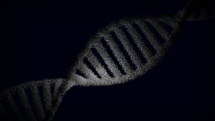 Artistic rendering of a DNA strand with particle effects against a dark background.