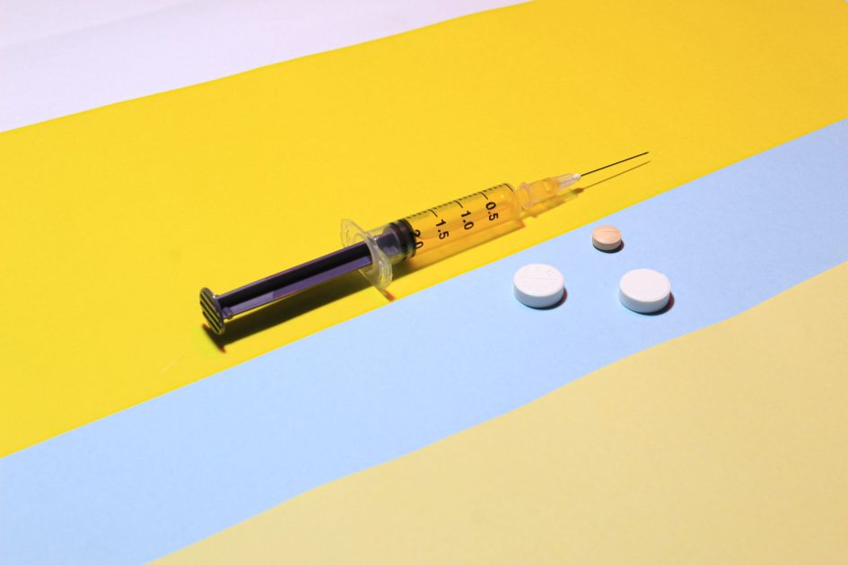 Microfluidics dalam Farmasi: 7 Aplikasi & Alat Terdepan 2024 1 A syringe and pills on a vibrant yellow and blue background, depicting healthcare theme.