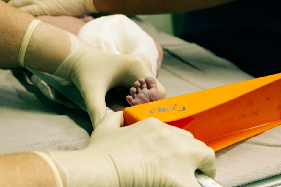 RS Bersalin Rusia Perketat Pemeriksaan: 7 Protokol Keamanan 1 Newborn's foot being measured by a nurse in medical setting with care.