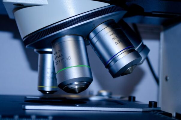 Detailed view of optical microscope lenses in a laboratory setting.