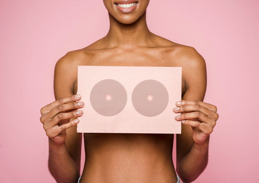 Jangan Tunggu Nyeri! 5 Gejala Awal Kanker Payudara 1 A conceptual image highlighting breast cancer awareness with a woman holding a symbolic card.